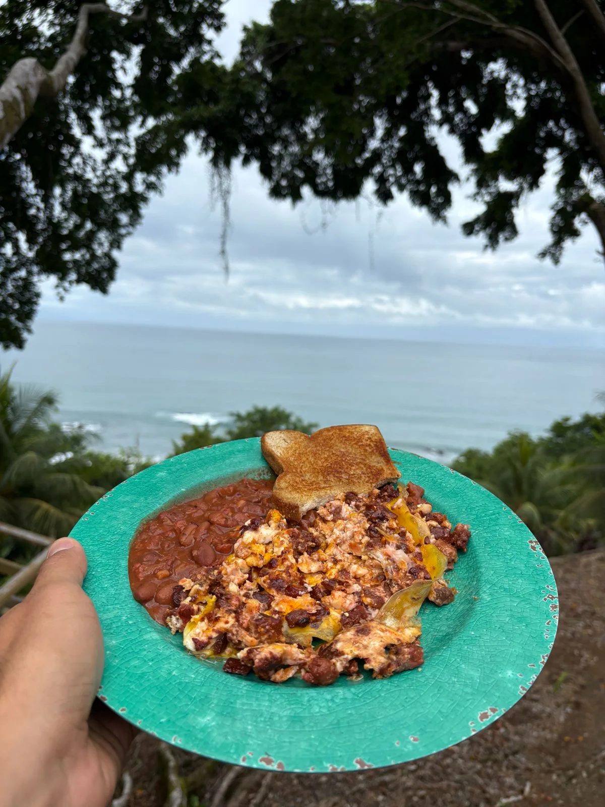 Huevos revueltos con Chorizeta, frijoles y pan tostado en un plato verde