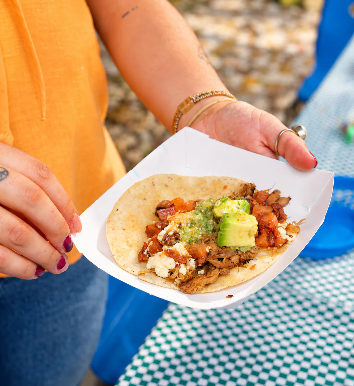 Taco de Chorizeta con aguacate, salsa verde y queso, en un plato de papel