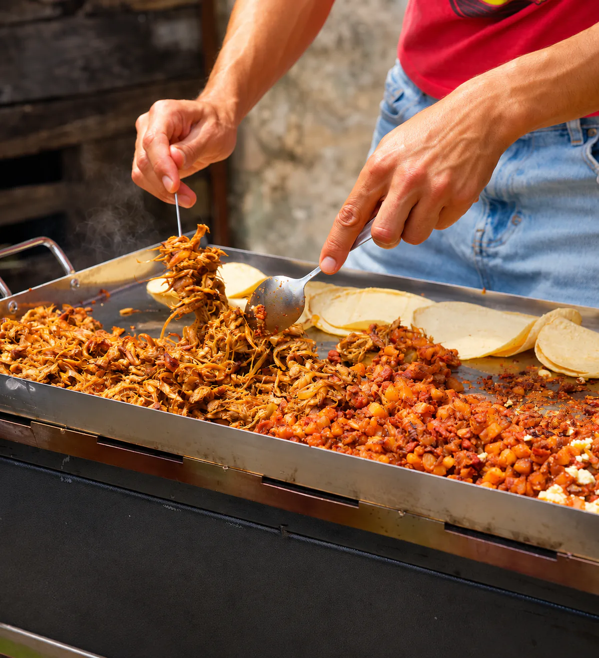 Zetas deshebradas y chorizeta cocinándose en una plancha junto a tortillas