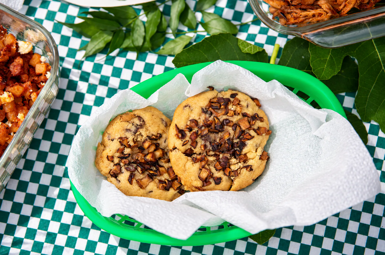 Dos galletas con chispas de chocolate en una canasta verde